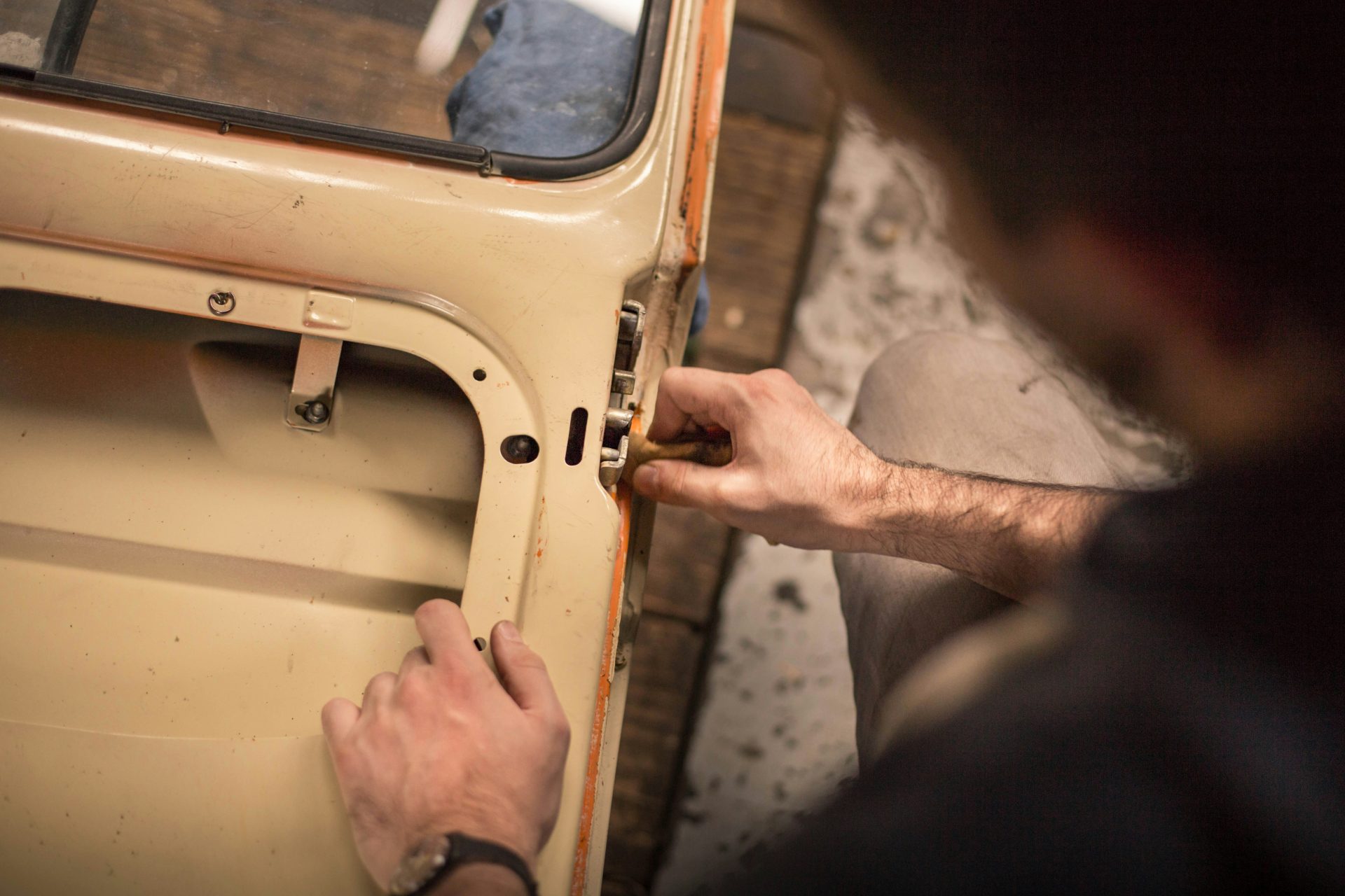 Mecánico trabajando en una puerta de un coche antiguo